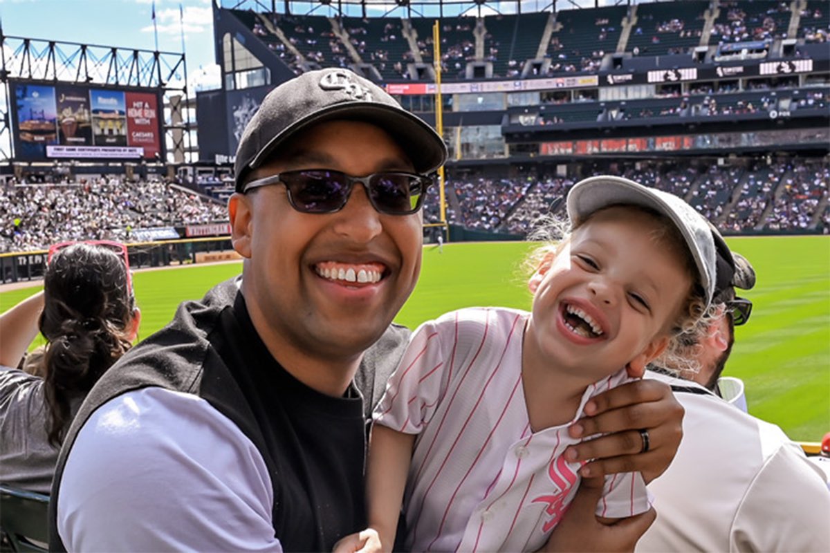 Me and my daughter in the stands at a White Sox game, both laughing at the camera, the outfield behind us.